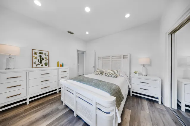 a view of a house with a big yard and palm trees