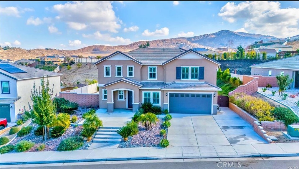 a front view of a house with a yard and potted plants