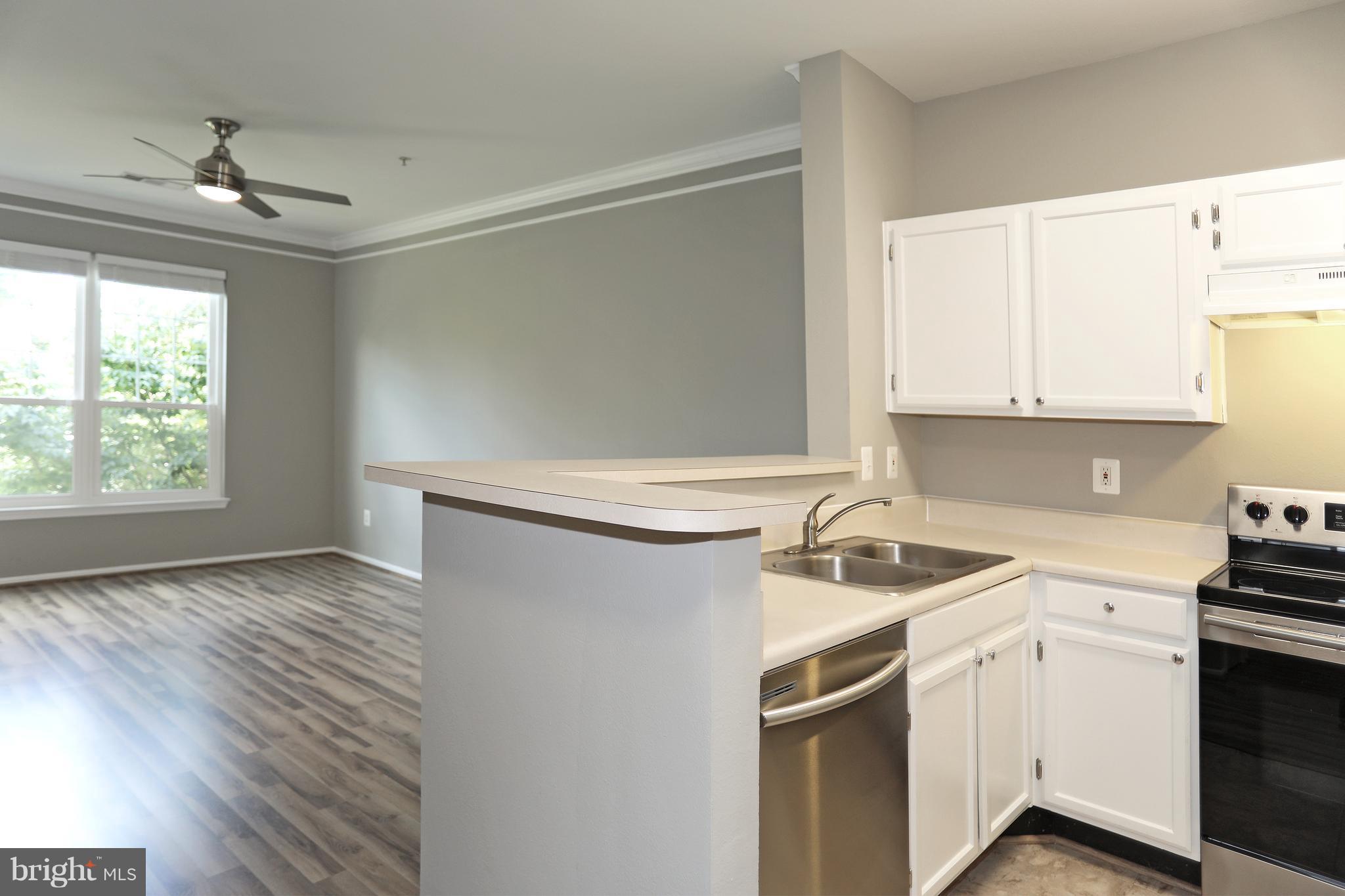 1601 Spring Gate Dr., Unit 1202 McLean, VA 22102 - Photo 2 of 30 a kitchen with a sink cabinets stainless steel appliances and a window