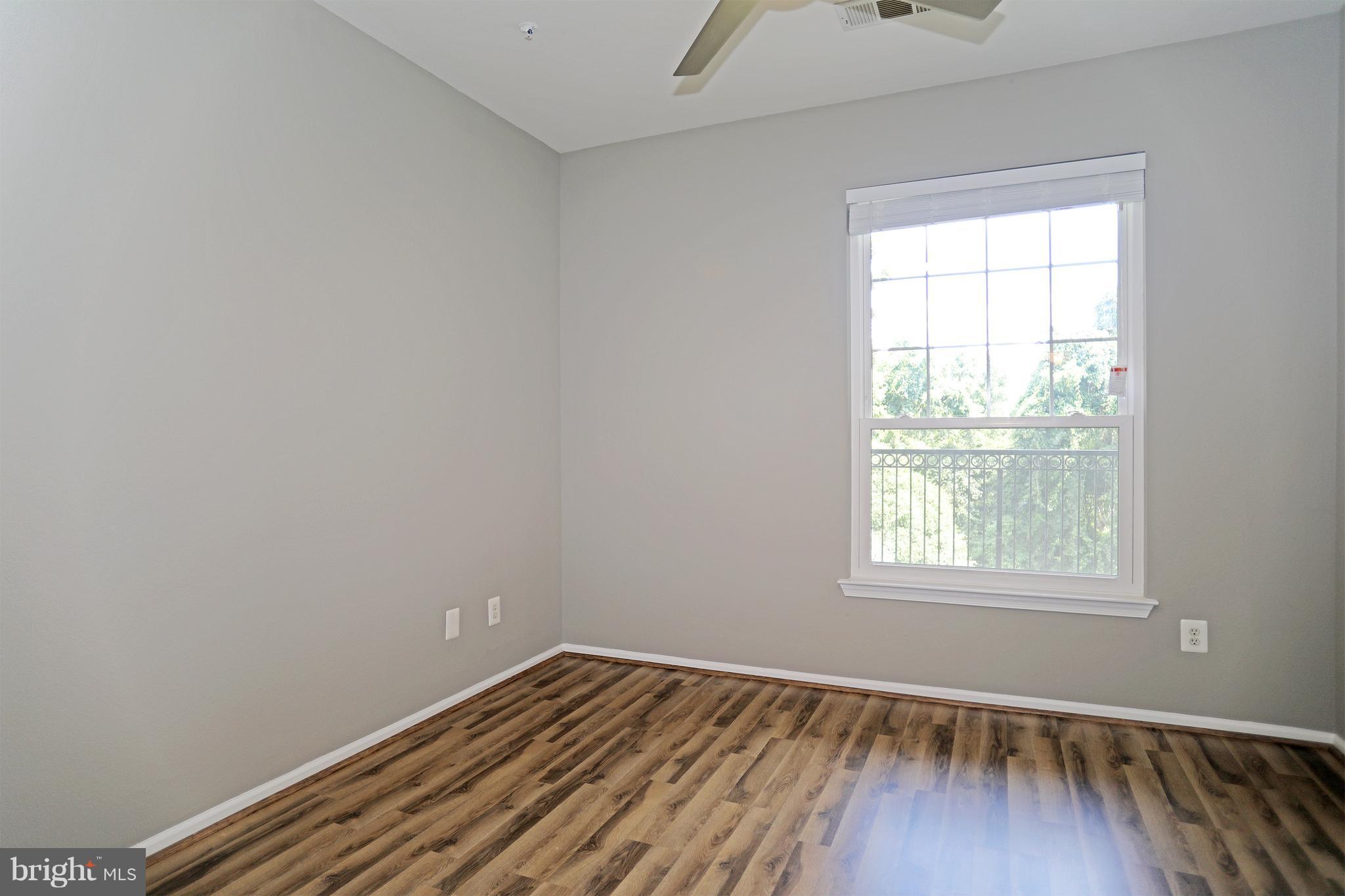 1601 Spring Gate Dr., Unit 1202 McLean, VA 22102 - Photo 13 of 30 an empty room with wooden floor and windows