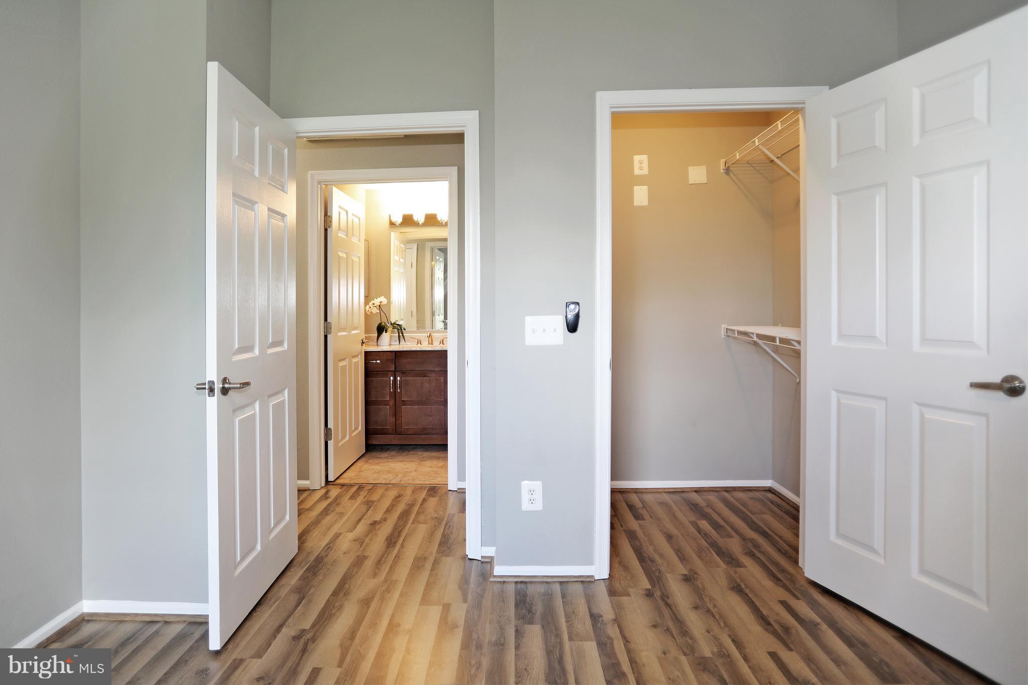 1601 Spring Gate Dr., Unit 1202 McLean, VA 22102 - Photo 16 of 30 a view of a hallway with wooden floor and a bathroom
