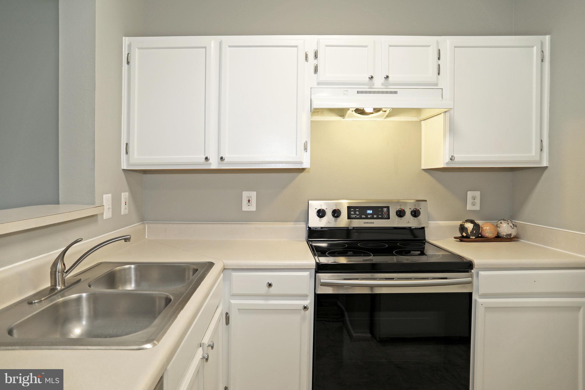 1601 Spring Gate Dr., Unit 1202 McLean, VA 22102 - Photo 3 of 30 a kitchen with a sink stove top oven and cabinets