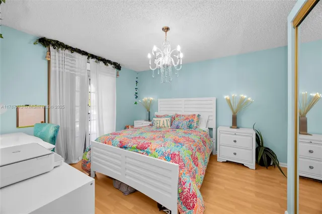 a bedroom with a bed and a chandelier