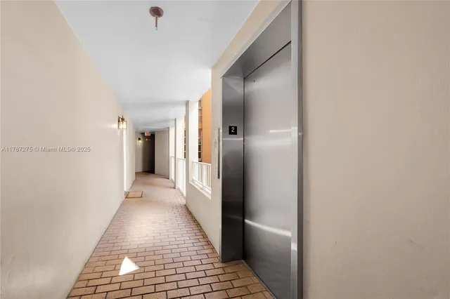 a view of a large building with a bench and plants