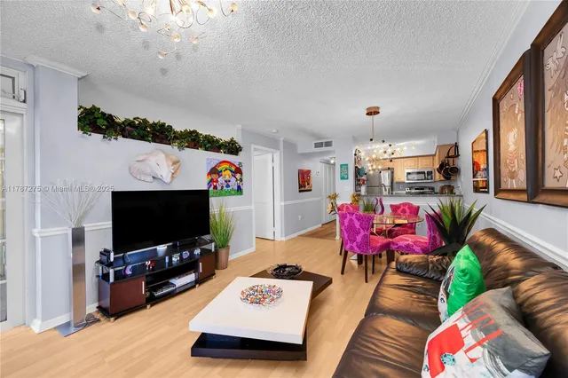 a living room with furniture a flat screen tv and a floor to ceiling window