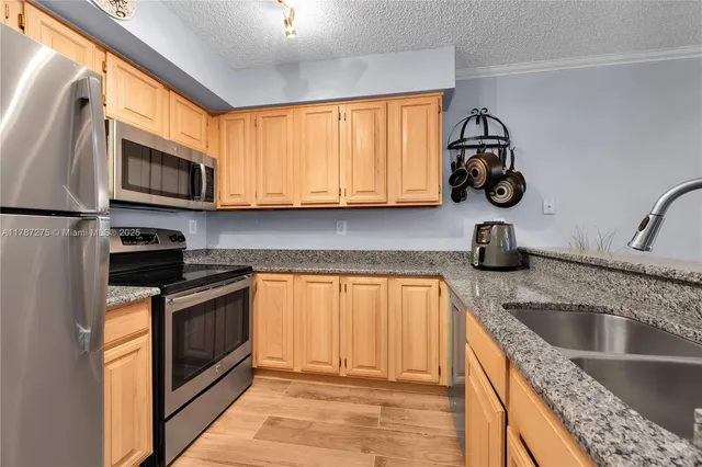 a kitchen with stainless steel appliances granite countertop a sink stove and microwave