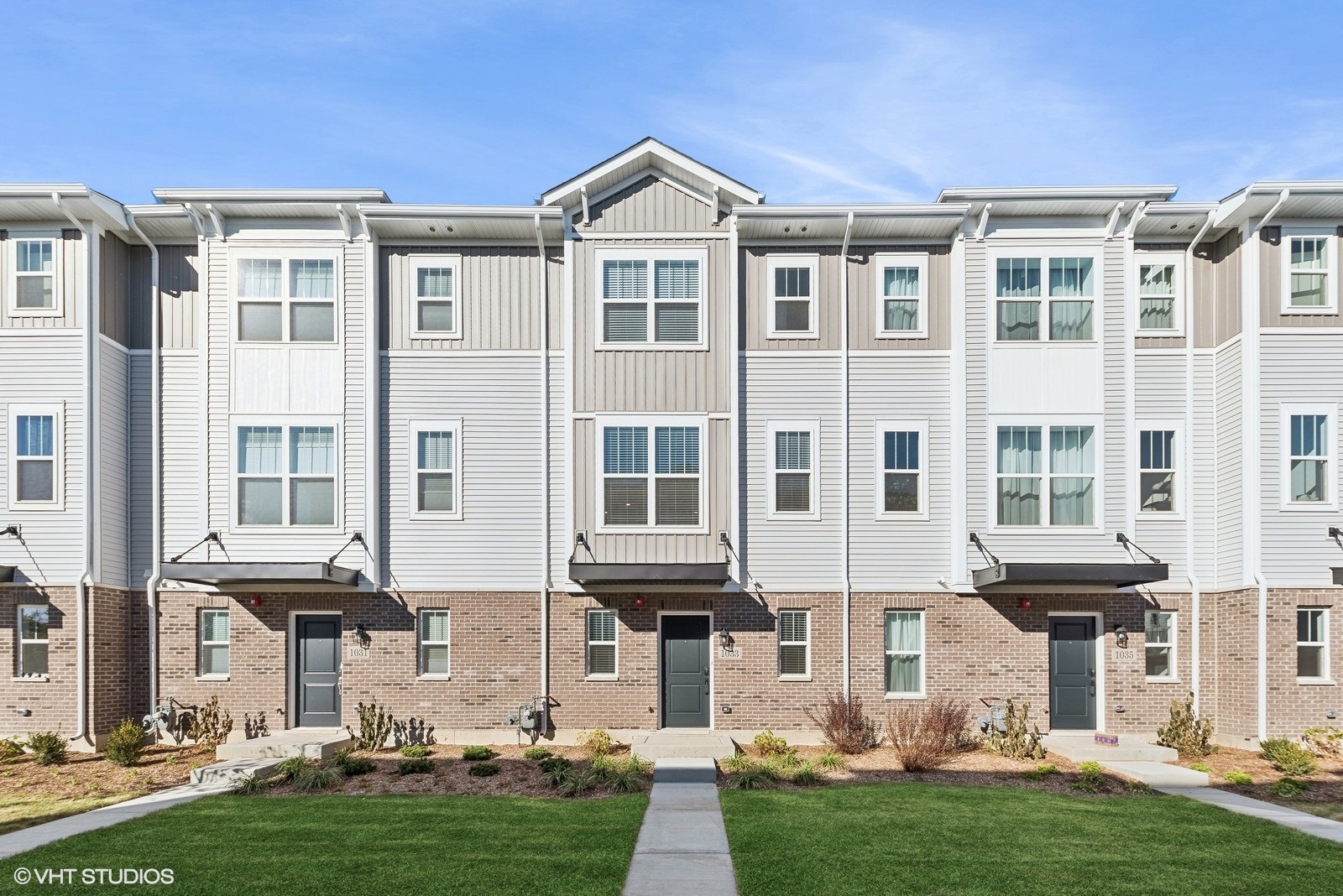 a front view of a residential apartment building with a yard