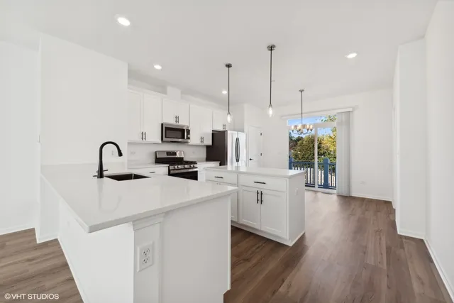 a kitchen with white cabinets and sink