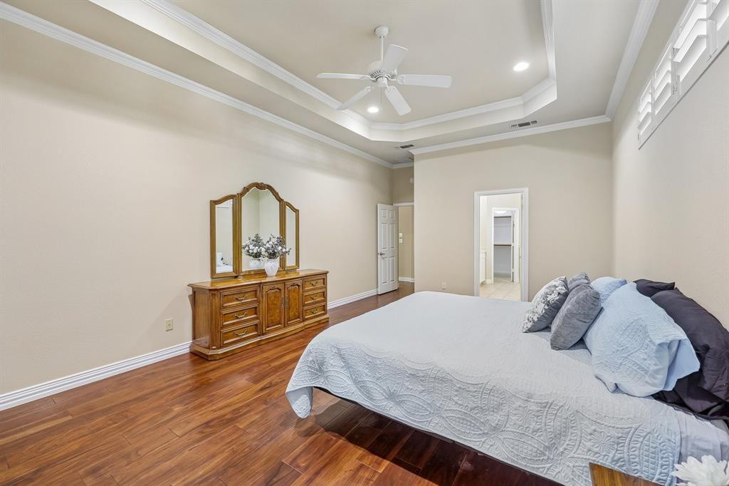 5409 Wedgefield Road Granbury, TX 76049 - Photo 23 of 39 Wood-finish flooring, tray ceiling with recessed lighting, ceiling fan, and plantation shutters