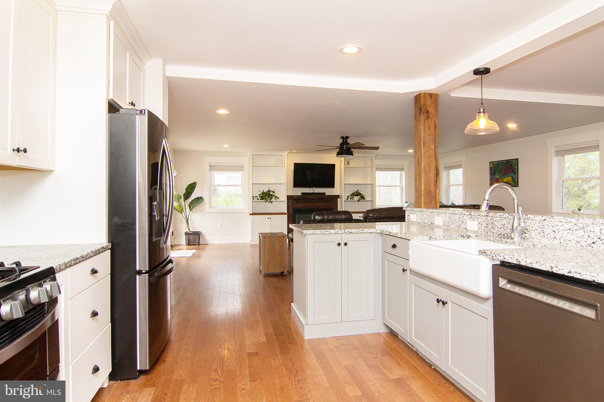 3061 Emmitsburg Road Gettysburg, PA 17325 - Photo 9 of 47 a kitchen with stainless steel appliances kitchen island granite countertop a stove top oven a sink a refrigerator and white cabinets with wooden floor