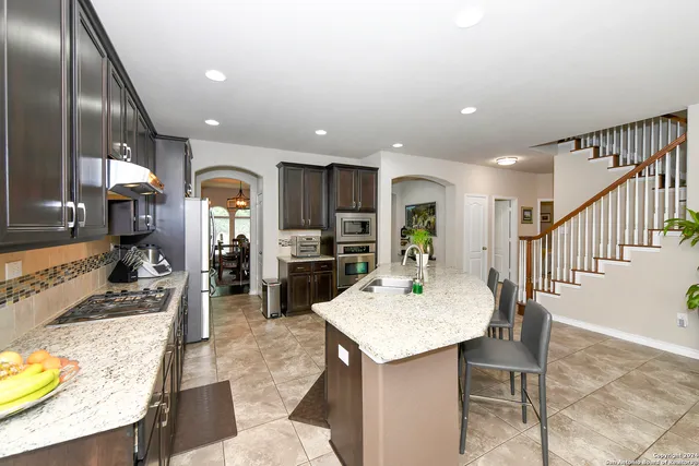 a view of kitchen with sink and refrigerator