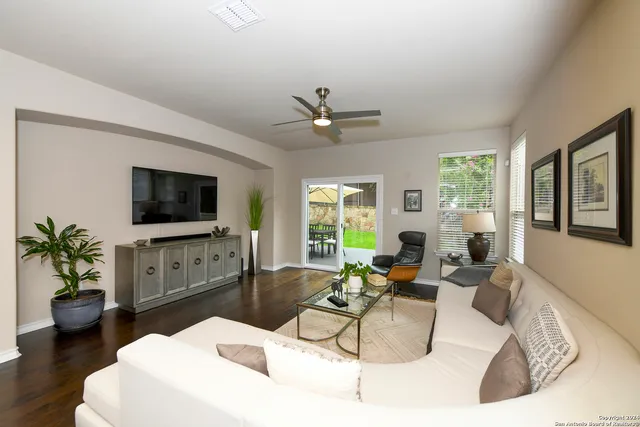 a living room with furniture a large window and a flat screen tv