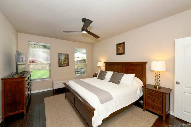 a bedroom with a bed and a flat tv screen on dresser