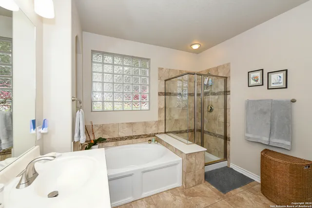 a bathroom with a tub a sink and glass door