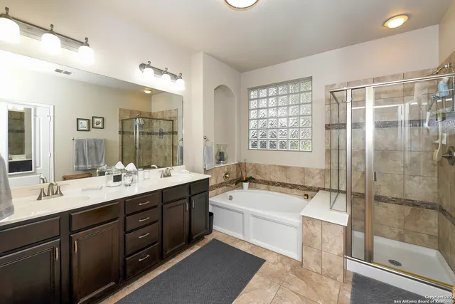 a bathroom with a bathtub shower sink and mirror