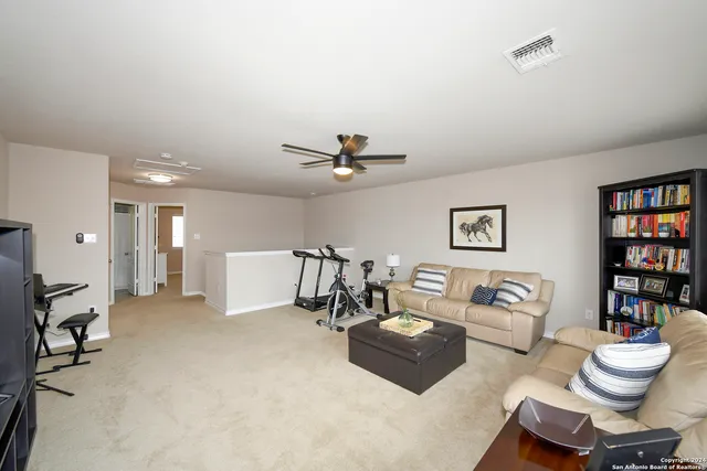 a living room with furniture and a book shelf