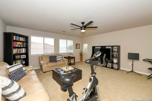a living room with furniture a window and a flat screen tv