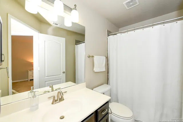 a bathroom with a sink vanity mirror and toilet