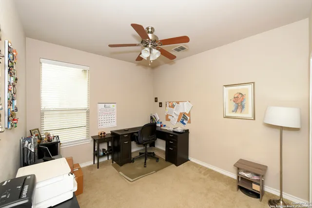 a view of a workspace with furniture and a window