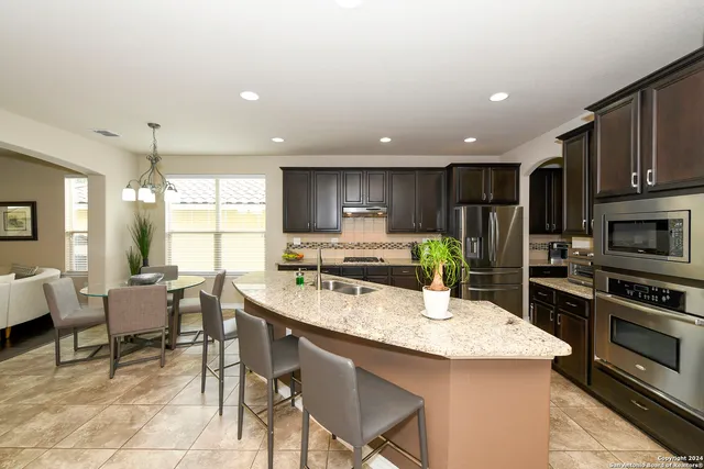 a kitchen with stainless steel appliances kitchen island granite countertop a sink and cabinets