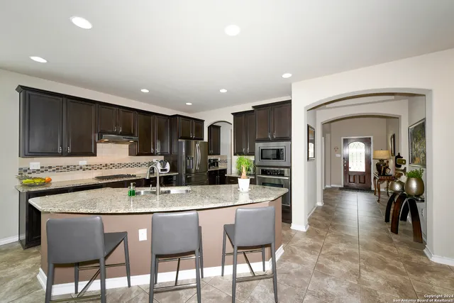 a kitchen with a dining table chairs and refrigerator