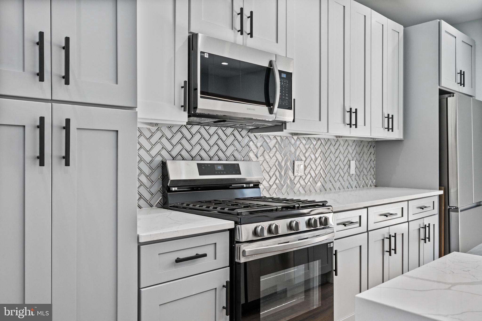 2202 East Huntingdon Street Philadelphia, PA 19125 - Photo 11 of 42 a kitchen with stainless steel appliances white cabinets and stove