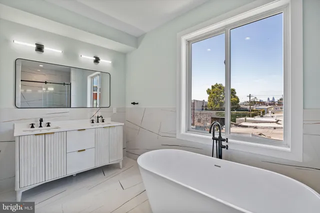 a bathroom with a tub sink and mirror