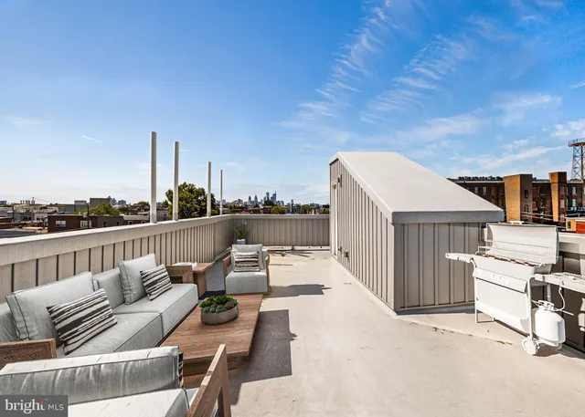 a view of roof deck with couches and wooden floor