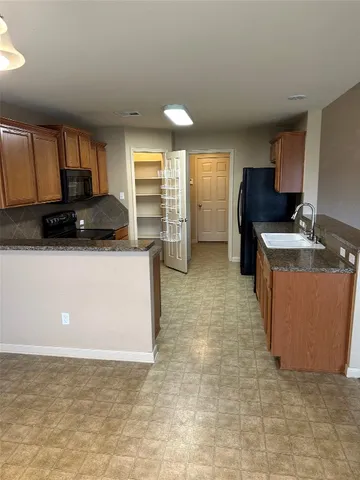 a kitchen with stainless steel appliances granite countertop a stove a sink and a microwave