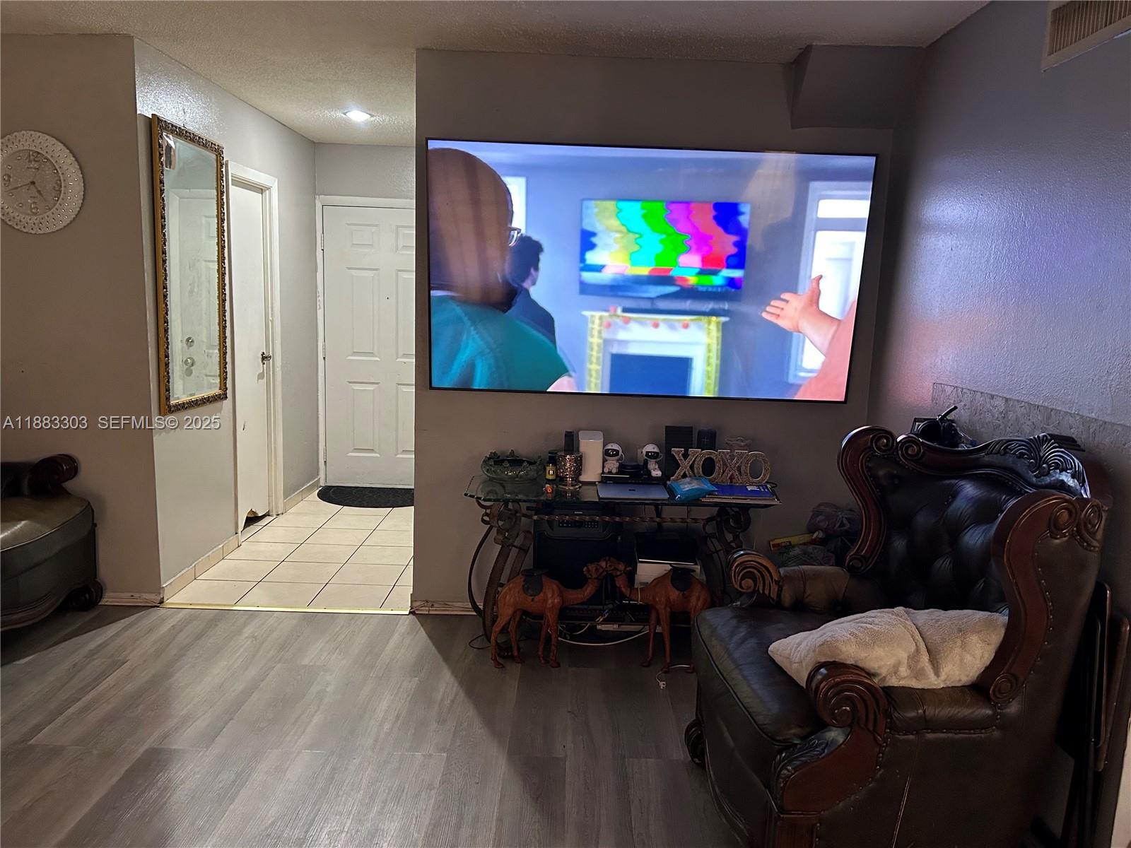 18111 Northwest 68th Avenue, Unit G206 Hialeah, FL 33015 - Photo 3 of 30 a living room with furniture and a flat screen tv