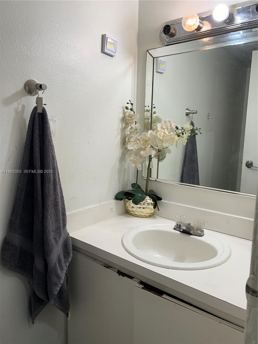 18111 Northwest 68th Avenue, Unit G206 Hialeah, FL 33015 - Photo 6 of 30 a bathroom with a sink and a mirror