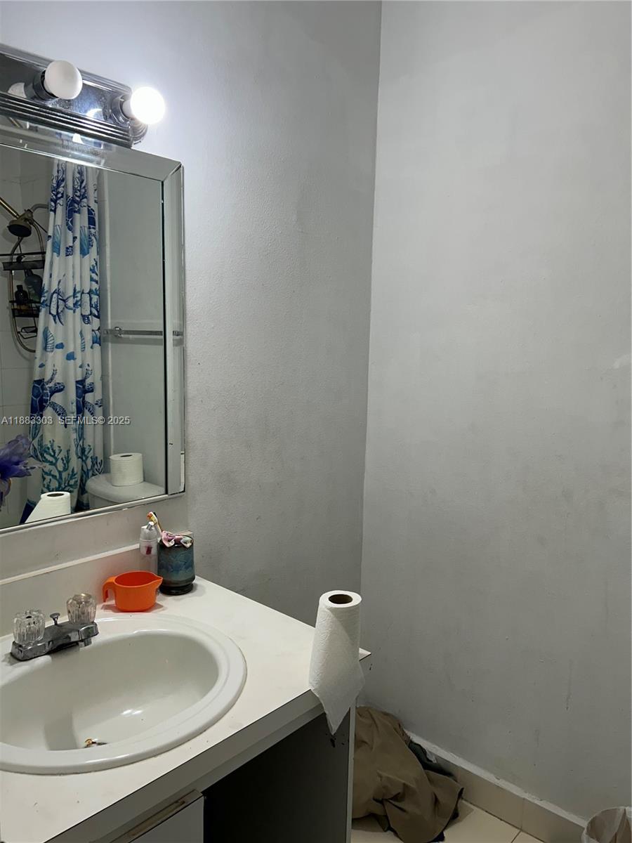 18111 Northwest 68th Avenue, Unit G206 Hialeah, FL 33015 - Photo 8 of 30 a bathroom with a sink and a mirror