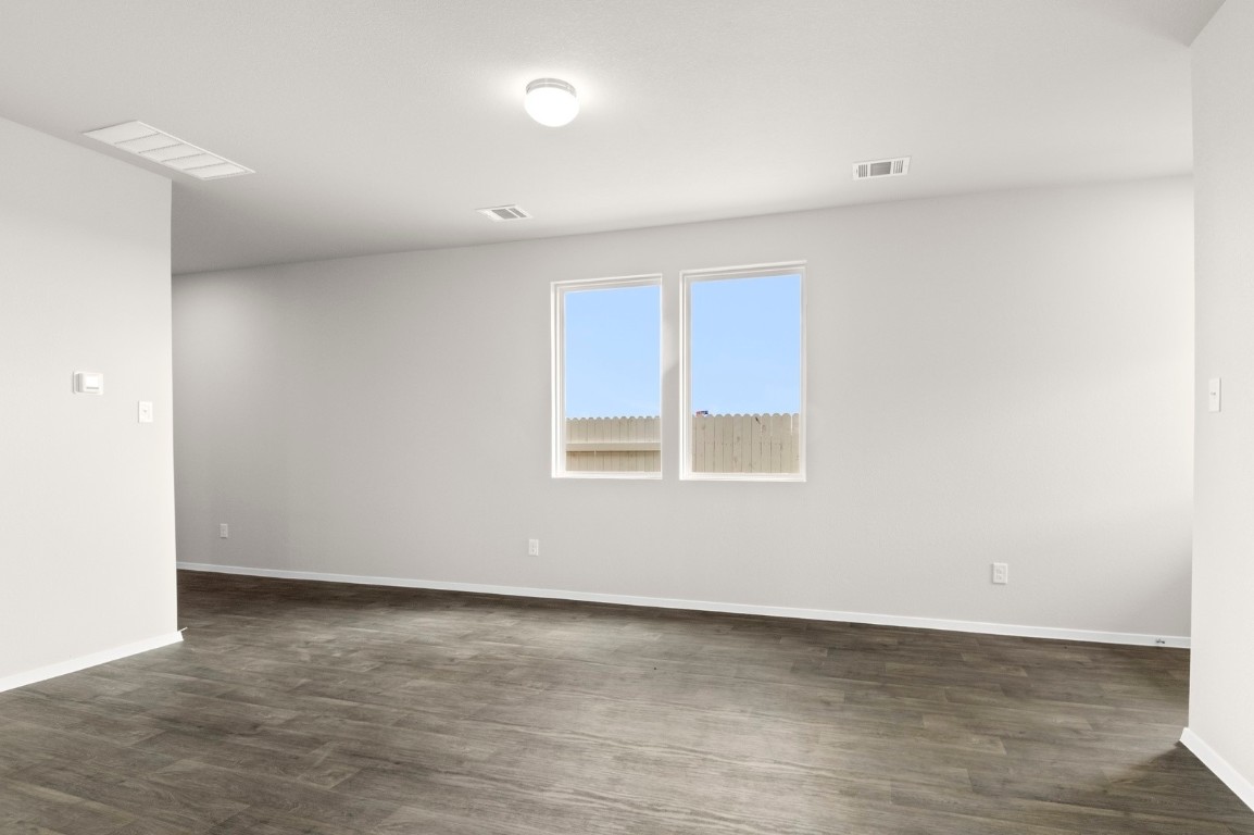 2963 Winding Creek Road Kyle, TX 78640 - Photo 11 of 28 a view of an empty room with wooden floor and a window