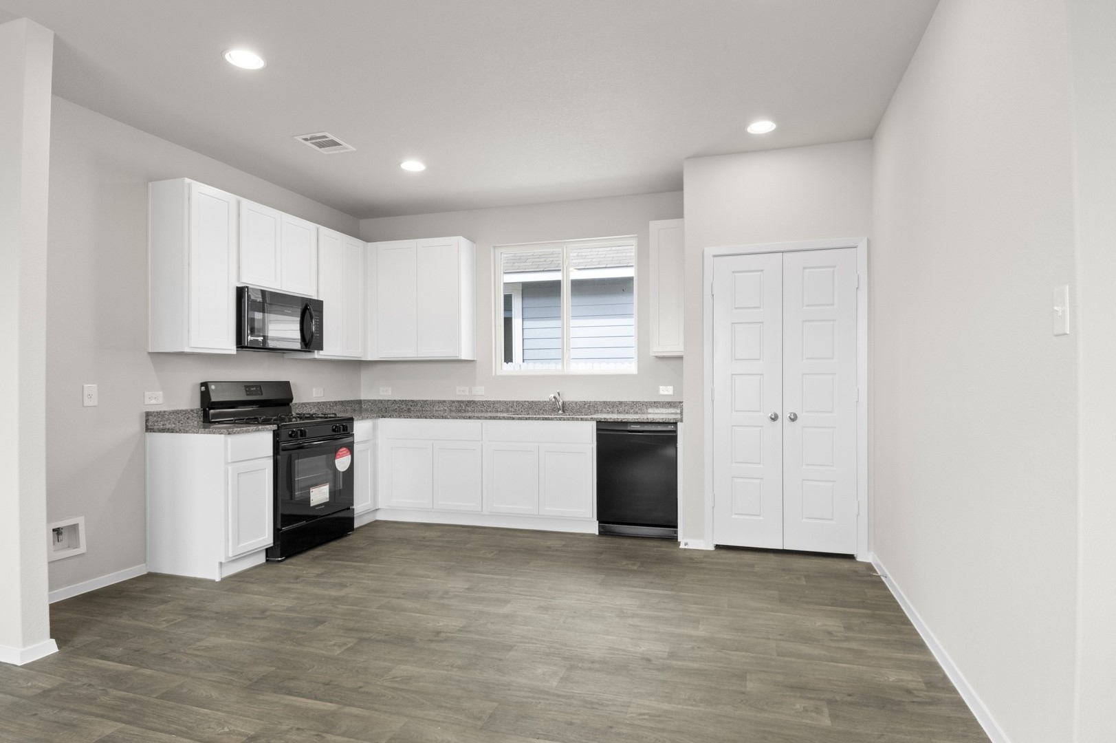 2963 Winding Creek Road Kyle, TX 78640 - Photo 13 of 28 a large kitchen with a refrigerator and a stove top oven