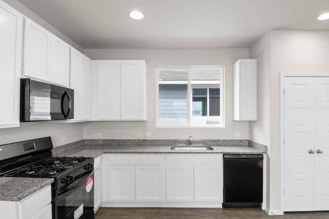2963 Winding Creek Road Kyle, TX 78640 - Photo 18 of 28 a kitchen with granite countertop a stove and a sink