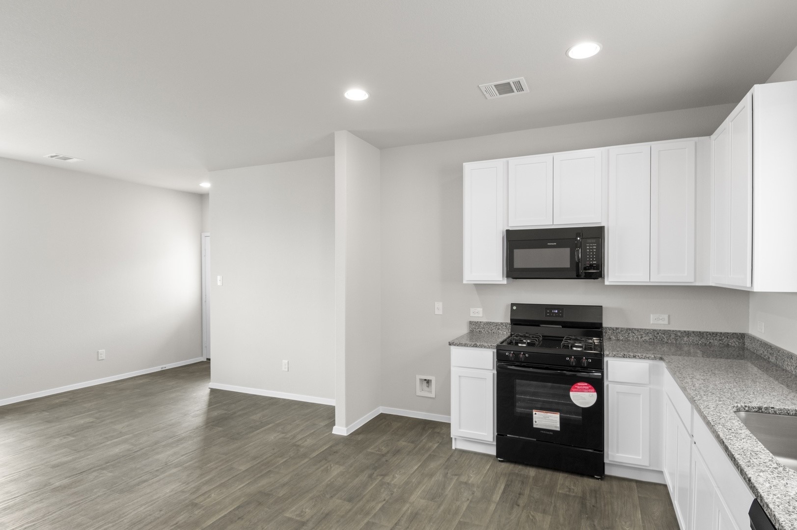 2963 Winding Creek Road Kyle, TX 78640 - Photo 19 of 28 a kitchen with wooden cabinets and a stove top oven