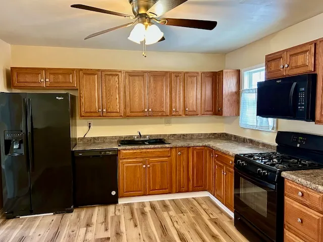 a kitchen with stainless steel appliances granite countertop a stove refrigerator and cabinets