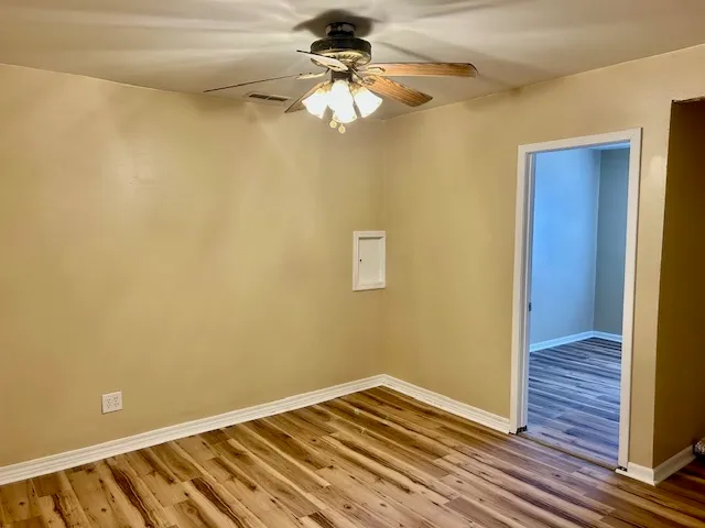 a view of a room with wooden floor and fan