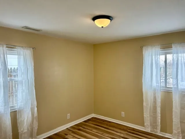 a view of a room with wooden floor and windows
