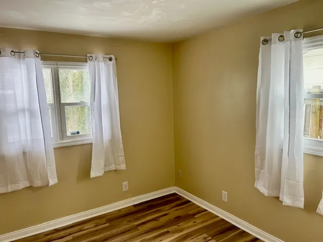 a view of a small space with wooden floor and a window