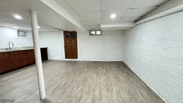 a view of a room with a sink and wooden floor