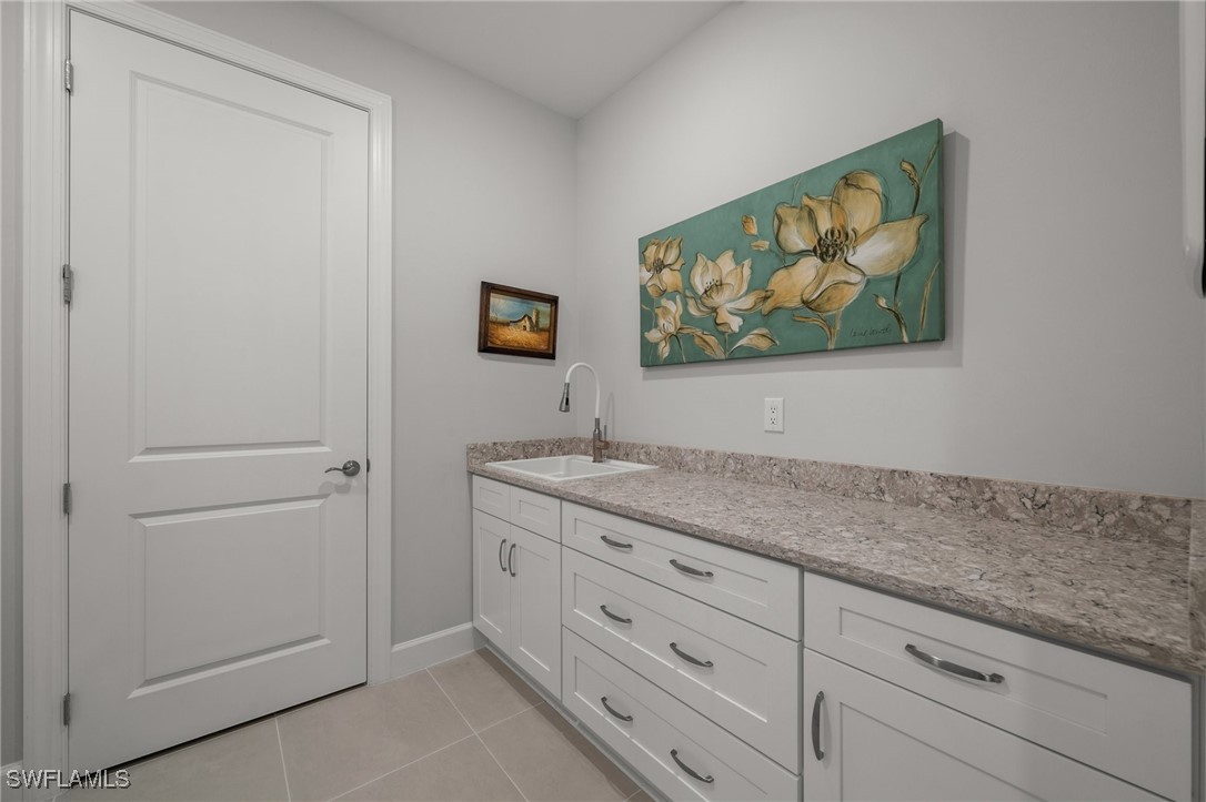 42243 Edgewater Drive Punta Gorda, FL 33982 - Photo 21 of 46 a bathroom with a granite countertop sink and a painting on the wall
