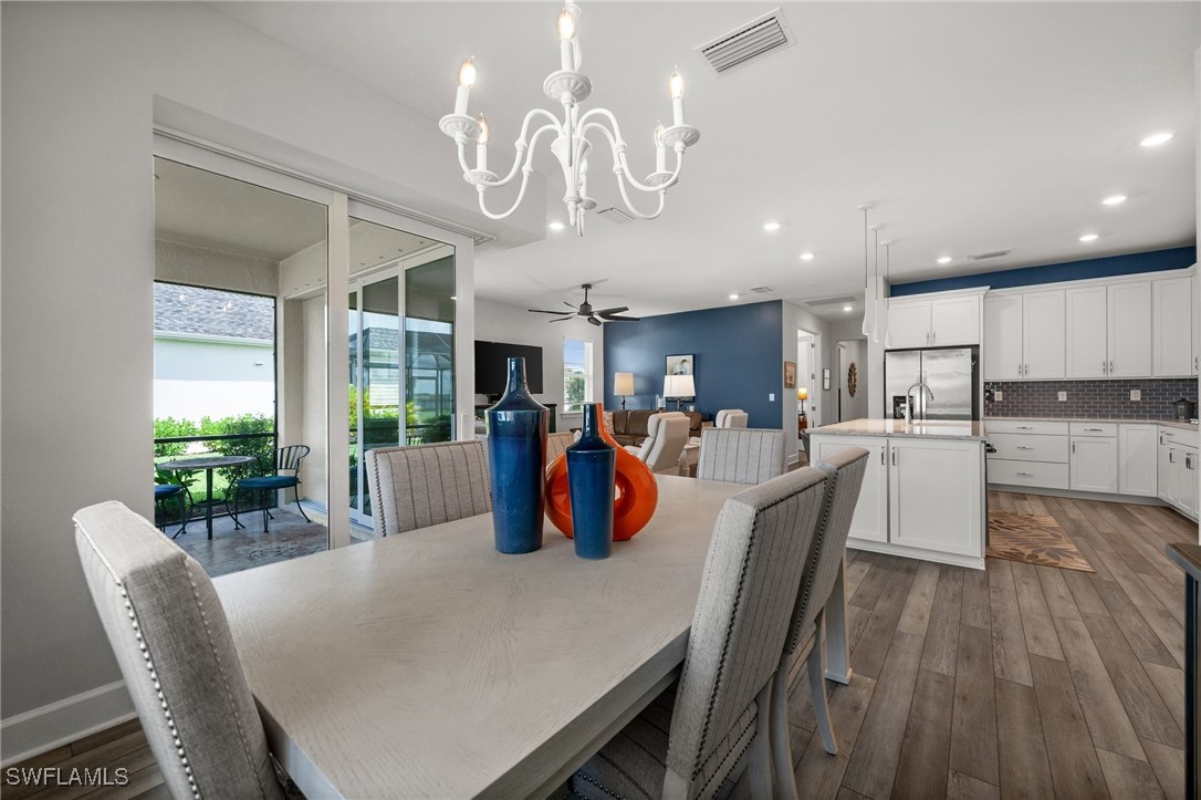 42243 Edgewater Drive Punta Gorda, FL 33982 - Photo 35 of 46 a view of a dining room with furniture a kitchen and chandelier