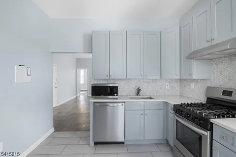 a kitchen with white cabinets and appliances
