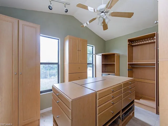 a kitchen with a refrigerator and a ceiling fan