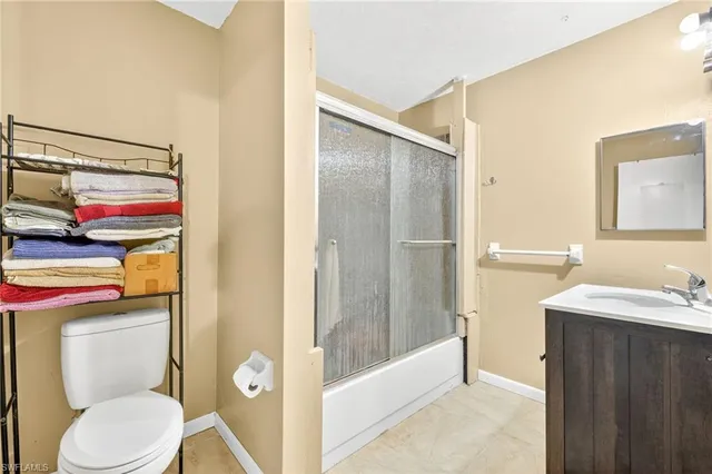 a bathroom with a granite countertop toilet sink and shower
