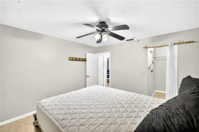 a bedroom with a bed and a chandelier fan