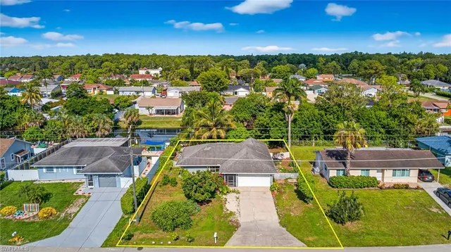 an aerial view of residential houses with outdoor space and trees