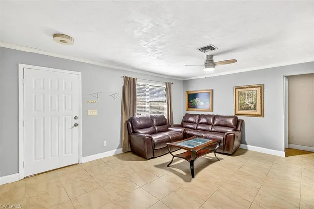 a living room with furniture and a ceiling fan