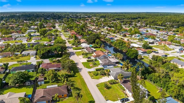 an aerial view of residential houses with outdoor space and trees